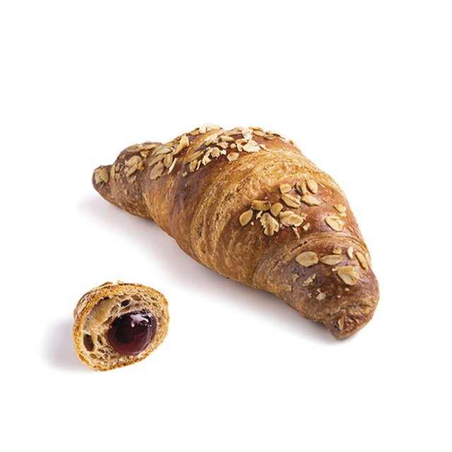 Croissant s ovesnými vločkami, menší kousek rozříznutý s náplní z tmavého lesního ovoce, na bílém pozadí