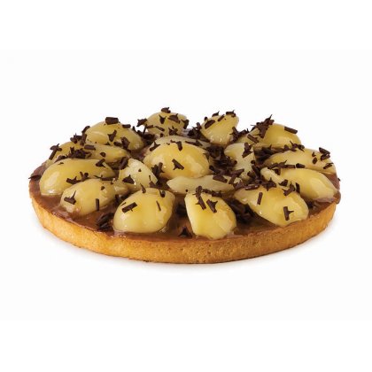 Kulatý koláč s karamelizovaným korpusem, plátky glazované hrušky a čokoládovými hoblinami.