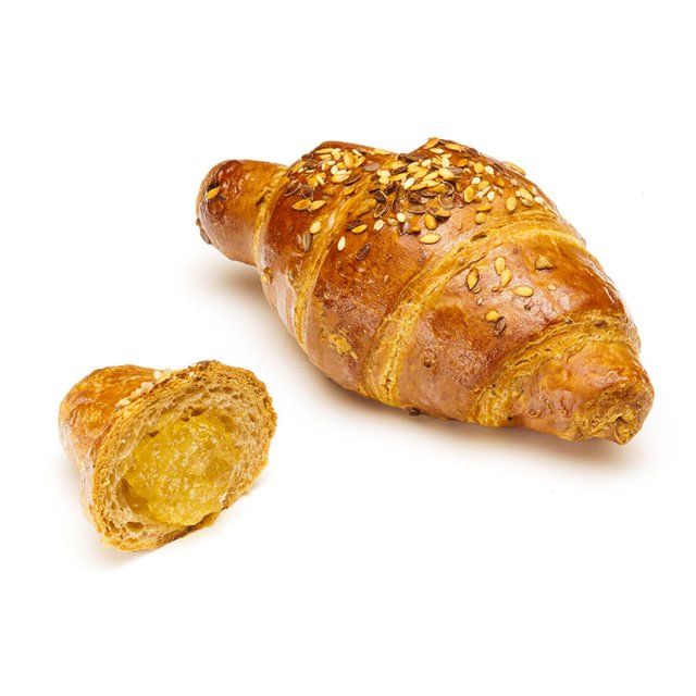 Zlatý vícezrnný croissant se semínky, menší kousek s měkkou žlutou náplní, na bílém pozadí