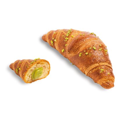 Zlatý croissant posypaný nasekanými pistáciemi, polovina odhaluje krémovou zelenou pistáciovou náplň.