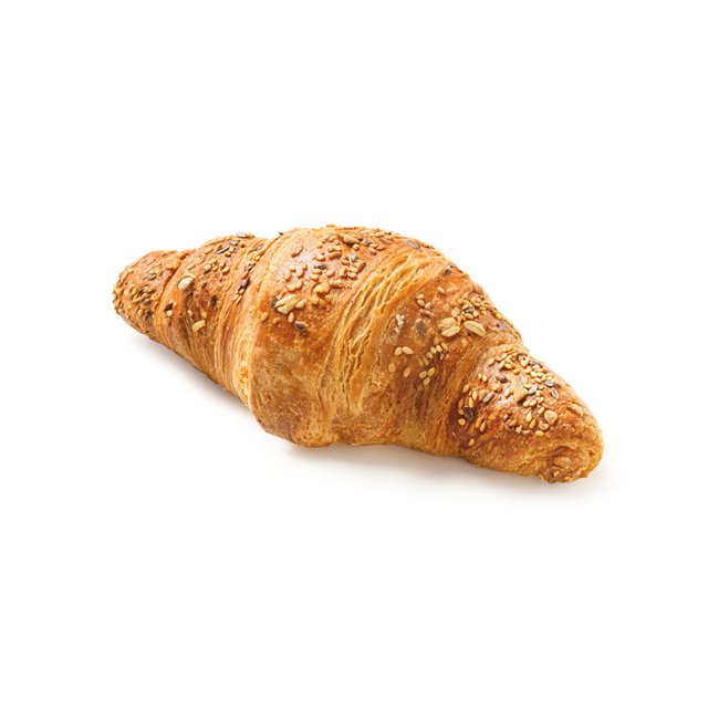 Do zlatova upečený vícezrnný croissant se semínky a ovesnými vločkami na bílém pozadí.