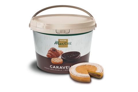 Velký kbelík roztíratelného krému Master Martini Caravella, s obrázky croissantu a sušenek, vedle plátku...