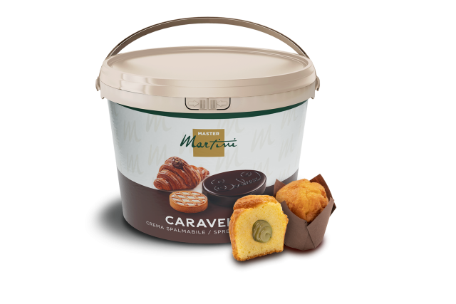 Velký kbelík roztíratelného krému Master Martini Caravel vedle rozkrojeného plněného muffinu a celého muffinu.