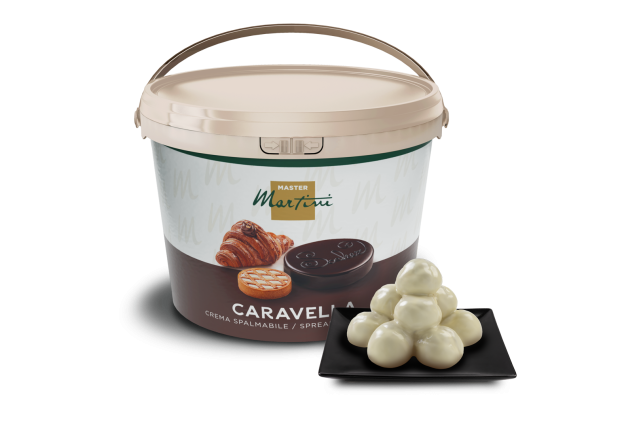 Kelímek krémové pomazánky Master Martini Caravella s lanýži z bílé čokolády na černém čtvercovém talíři.