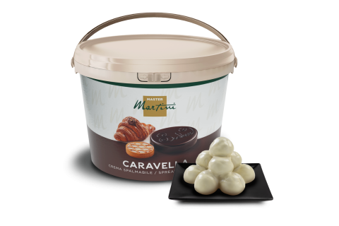 Kelímek krémové pomazánky Master Martini Caravella s lanýži z bílé čokolády na černém čtvercovém talíři.