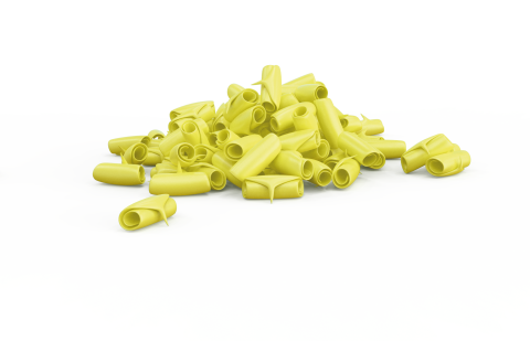 Žluté, zakřivené trubkovité tvary podobné rigatoni rozházené na bílém pozadí.